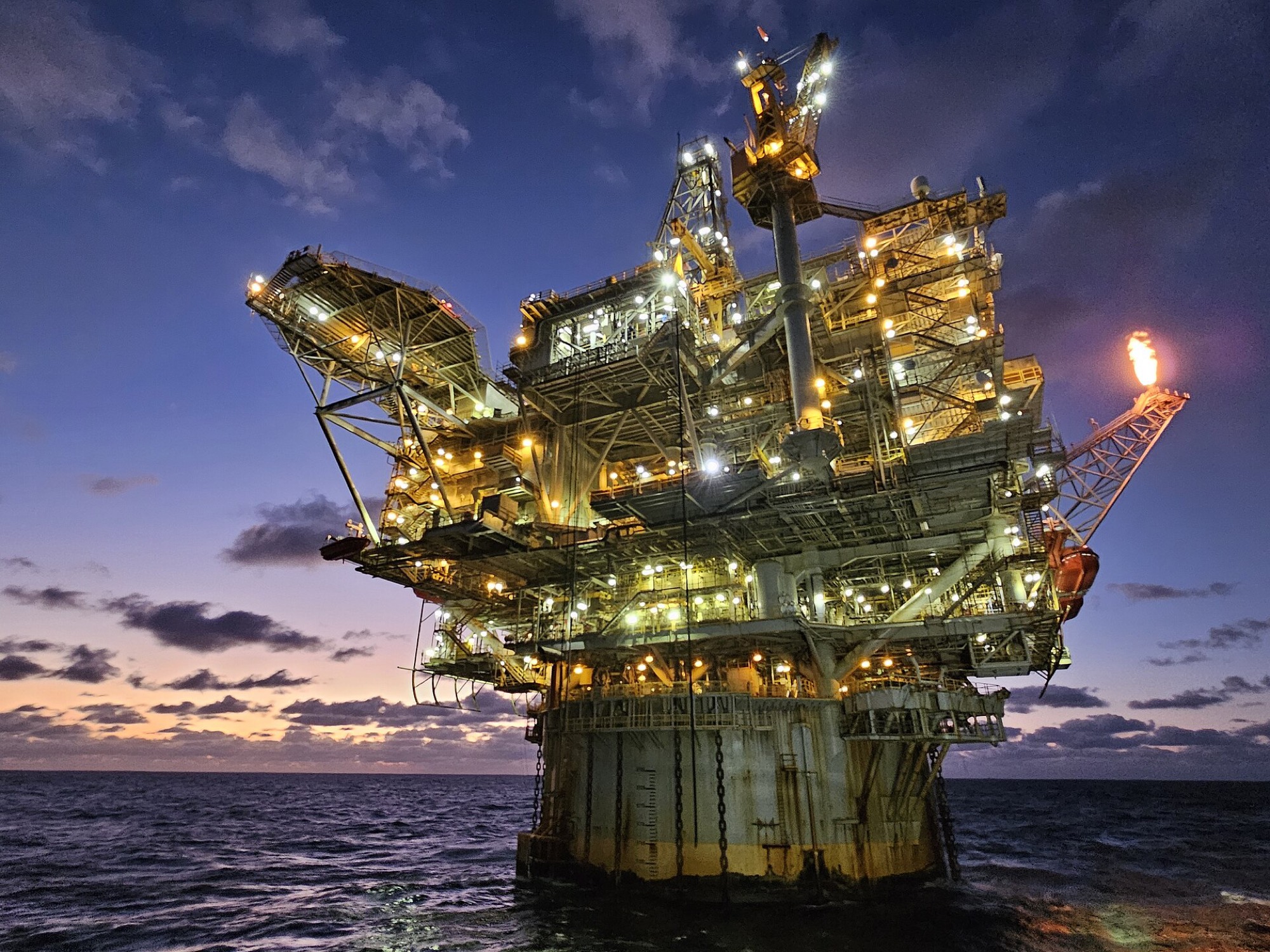 Offshore production platform lit at dusk